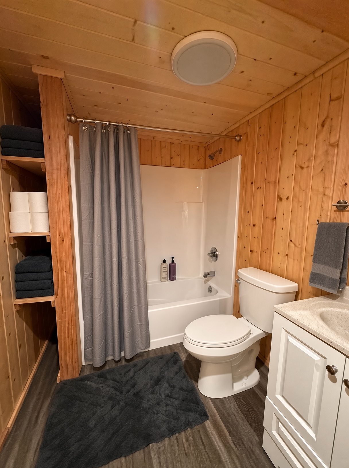 Downstairs bathroom — tub/shower combo and towel shelves