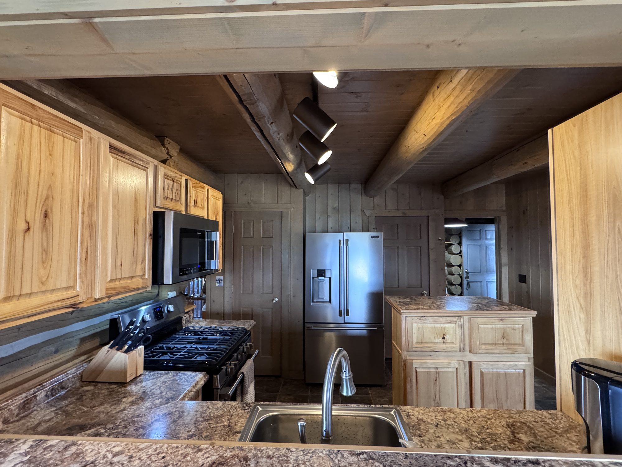 Kitchen with island, gas range, and stainless appliances
