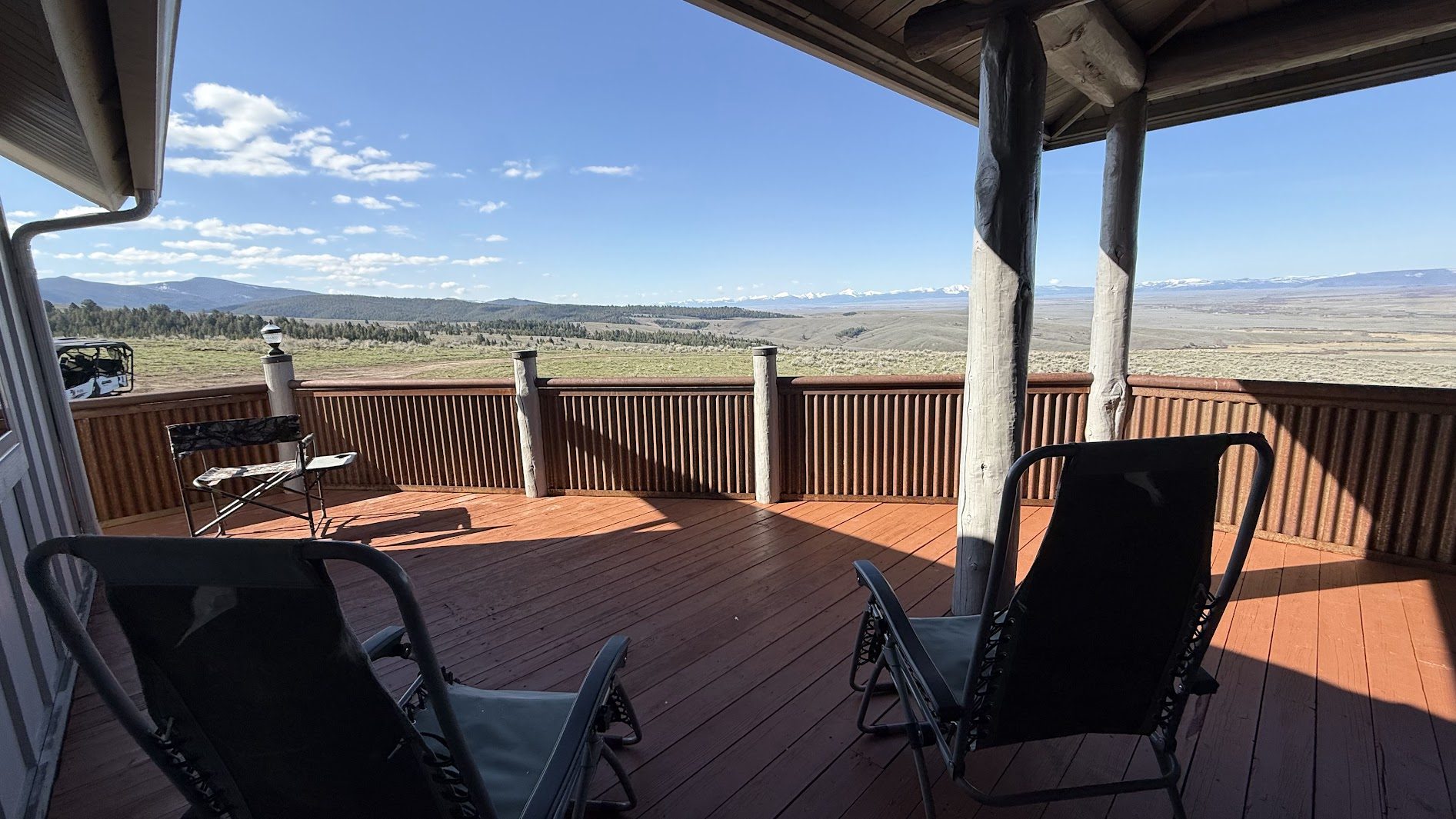 Covered deck with lounge chairs and snow-capped mountain views