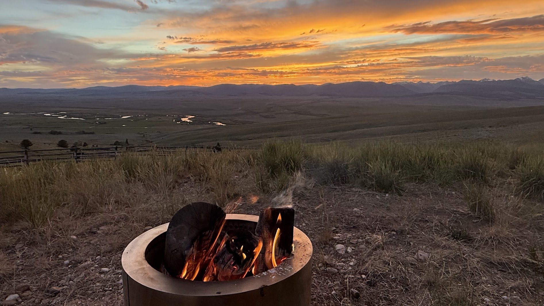 Fire pit at sunset — the Big Hole River glowing in the valley below